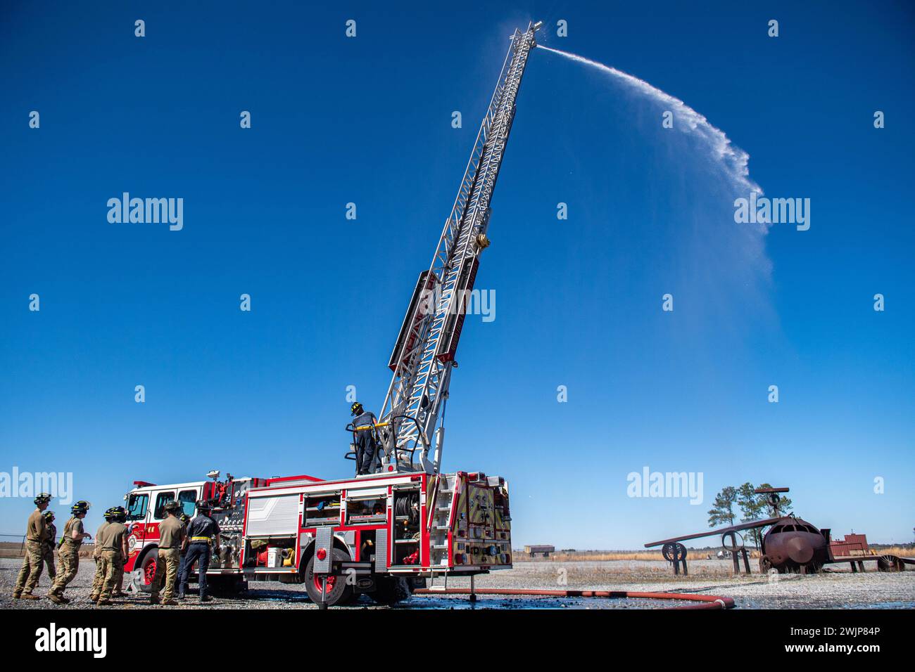 Die US-Luftwaffe, die der 23rd Civil Engineer Squadron zugeteilt sind, nehmen zusammen mit den Feuerwehrleuten des Lowndes County und der Valdosta Fire Department am 14. Februar 2024 an der Luftfahrtschulung auf der Moody Air Force Base, Georgia, Teil. Sowohl militärische als auch zivile Feuerwehrleute müssen eine Luftzertifizierung für den Betrieb der 75-Fuß-Leiter, die auf dem Feuerwehrwagen aufliegt, erhalten. (Foto der U.S. Air Force von Senior Airman Courtney Sebastianelli) Stockfoto