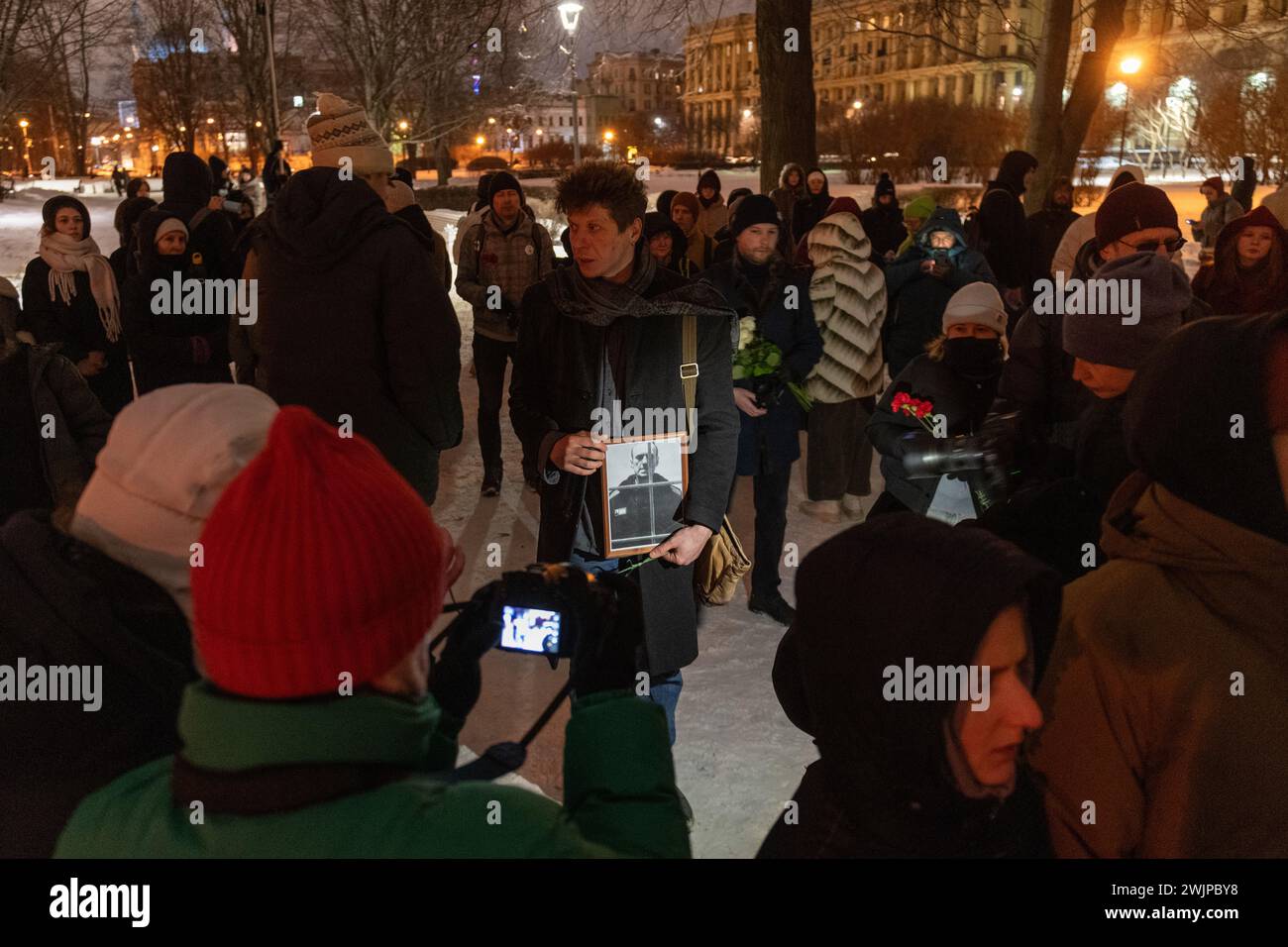 St. Petersburg, Russland. Februar 2024. Ein Mann hält Blumen und ein Porträt des russischen Oppositionsführers Alexej Nawalny am Denkmal der Opfer der politischen Unterdrückung in St. Petersburg. Quelle: SOPA Images Limited/Alamy Live News Stockfoto