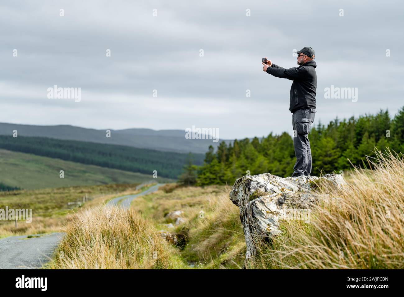 Ein Tourist macht ein Foto am Glengesh Pass, einer atemberaubenden Passstraße im Westen Donegals zwischen der historischen Stadt Ardara und dem schönen Dorf GLE Stockfoto