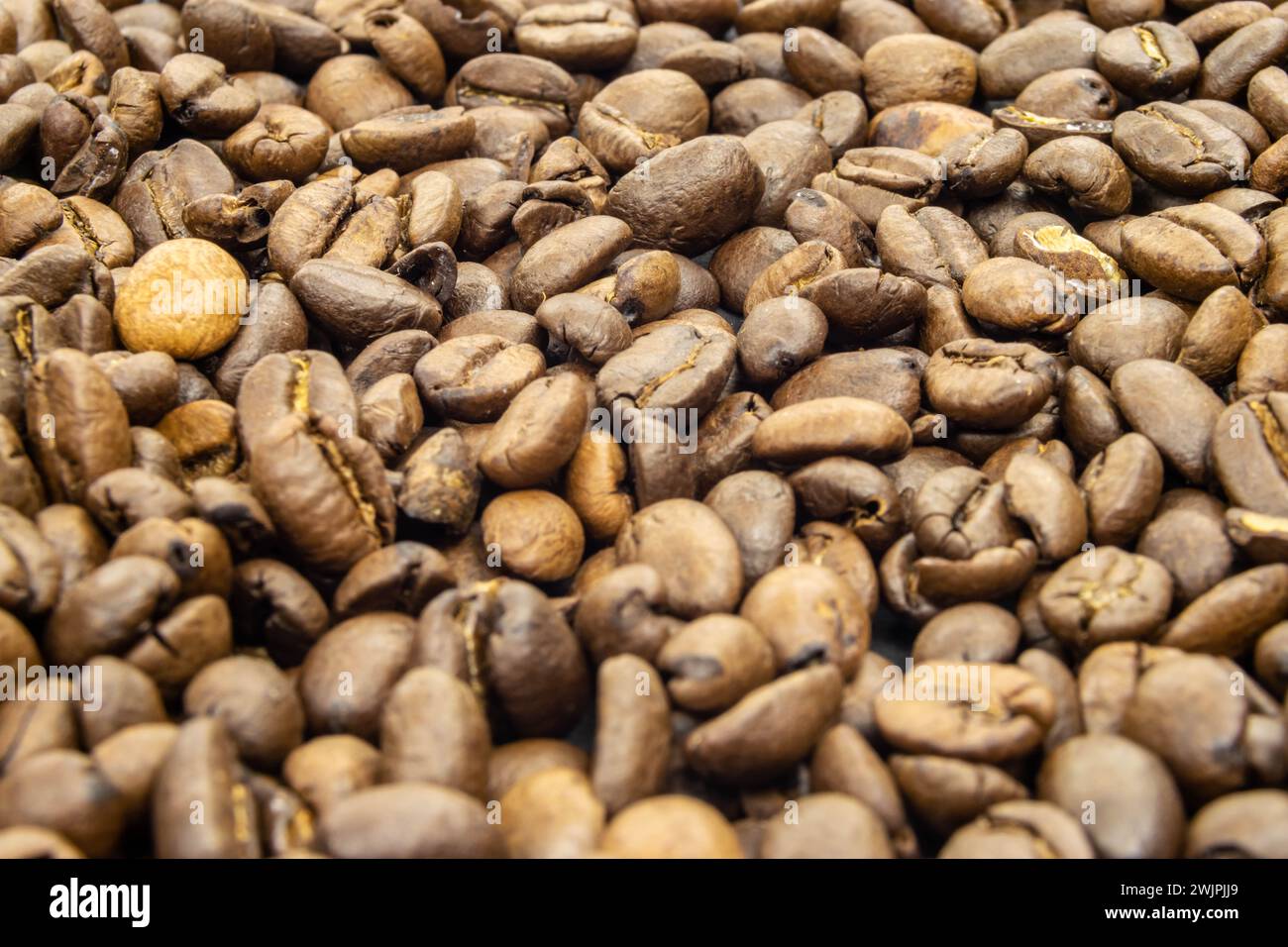 Kaffee auf schwarzer Oberfläche. Dicht geröstete Bohnen von Arabica Robusta wunderschöner frischer Espresso Mocha Lungo perfekter Start in den Tag. Stockfoto