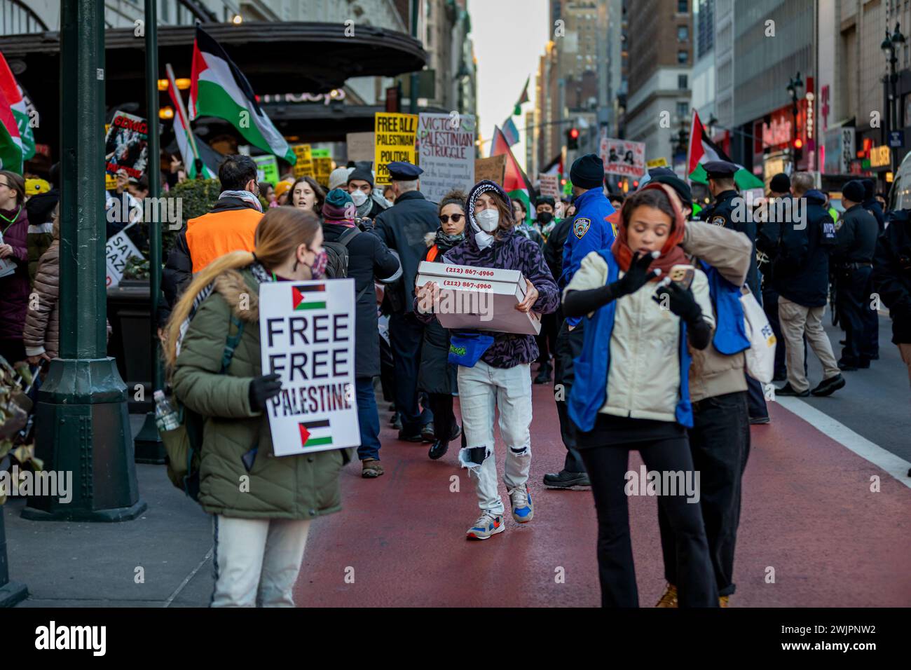 NEW YORK, NEW YORK – 16. FEBRUAR: Eine Person läuft mit Pizzakartons während eines stadtweiten Schulbesuchs, der zu einem dauerhaften Waffenstillstand bei einer Kundgebung vor der Hauptfiliale der New York City Public Library am 16. Februar 2024 in New York City aufruft. Das Gesundheitsministerium im Gazastreifen sagte, dass die Zahl der Todesopfer seit Beginn des israelisch-Hamas-Konflikts am 7. Oktober 2023 über 30.000 Menschen liegt, davon etwa zwei Drittel Frauen und Kinder. (Foto: Michael Nigro/SIPA USA) Credit: SIPA USA/Alamy Live News Stockfoto