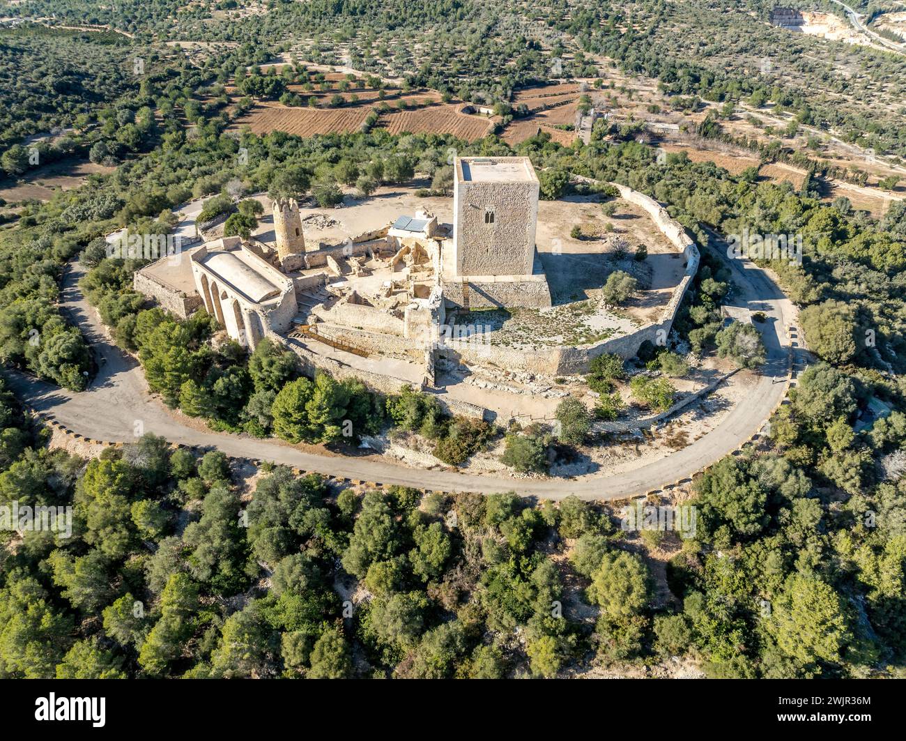 Blick aus der Vogelperspektive auf die Burg Ulldecona, den Gipfel der Serra Grossa, die ehemalige Grenzbefestigung, die alte Kirche, den emblematischen runden Turm und den quadratischen Donjon Stockfoto