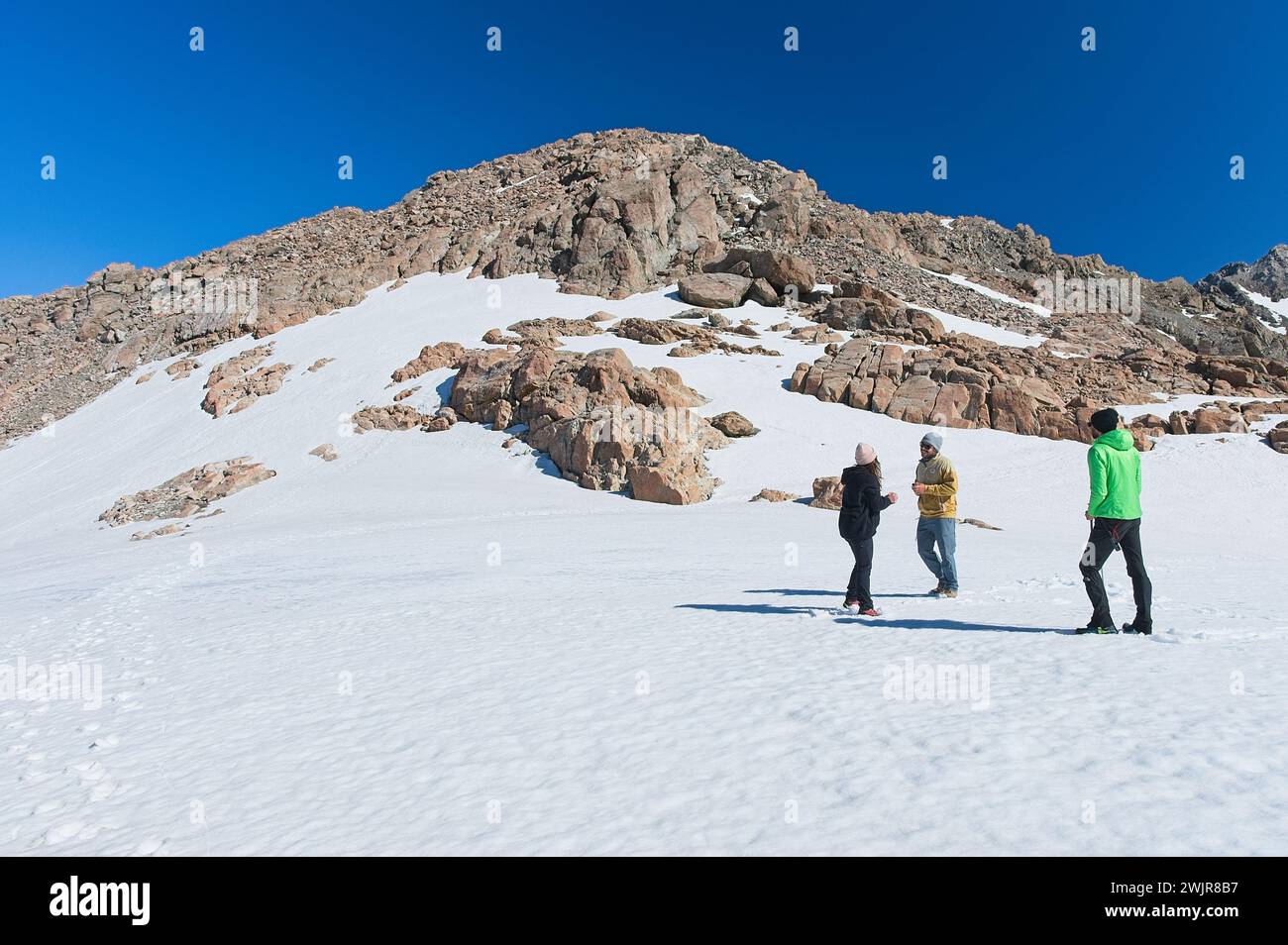 Abenteuer im Schnee: Freunde erkunden die malerische Wildnis mit Rocky Hills im Hintergrund Stockfoto