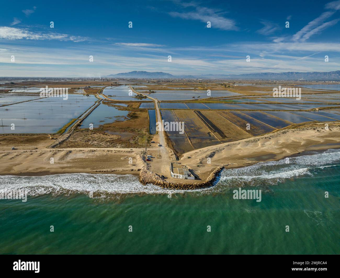 Blick aus der Vogelperspektive auf den Strand von Marquesa und das Restaurant Vascos, mit einem Felsdamm gegen die Regression des Ebro-Deltas (Tarragona, Katalonien, Spanien) Stockfoto