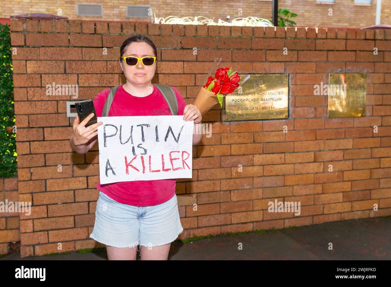 Sydney, Australien, 17. Februar 2024. Vor dem russischen Konsulat findet ein öffentliches Treffen statt, um Simeon Boikov, den „australischen Kosaken“, zu unterstützen, der derzeit aufgrund seines politischen Aktivismus im Konsulat residiert. Im Bild: Ein pro-ukrainischer Demonstrant mit einem Anti-Putin-Banner. Quelle: Robert Wallace / Wallace Media Network / Alamy Live News Stockfoto