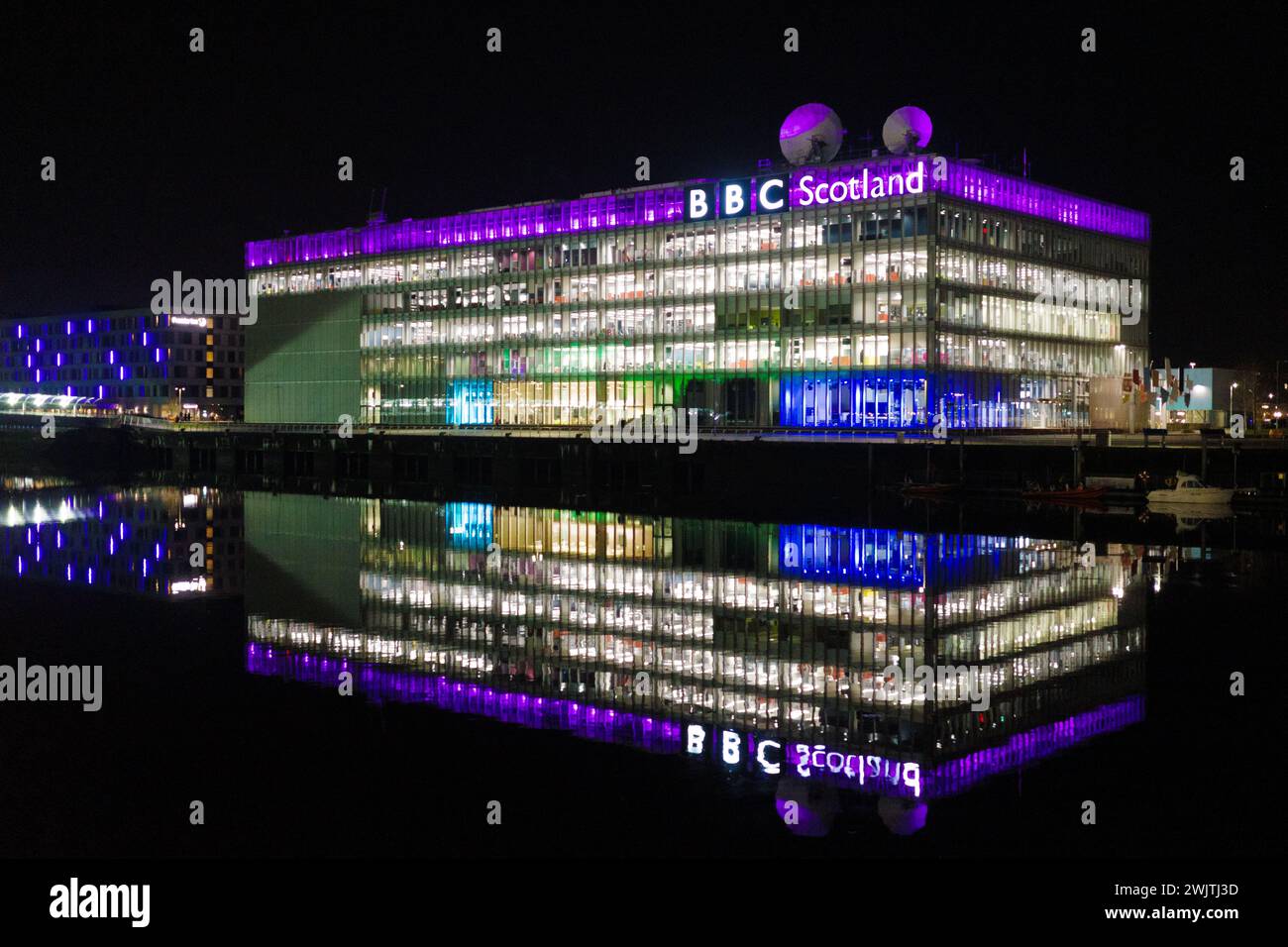 Glasgow Schottland: 11. Februar 2024: River Clyde bei Nacht mit dem BBC Scotland Gebäude beleuchtet mit Wasserrefelktion. BBC Pacific Quay Stockfoto