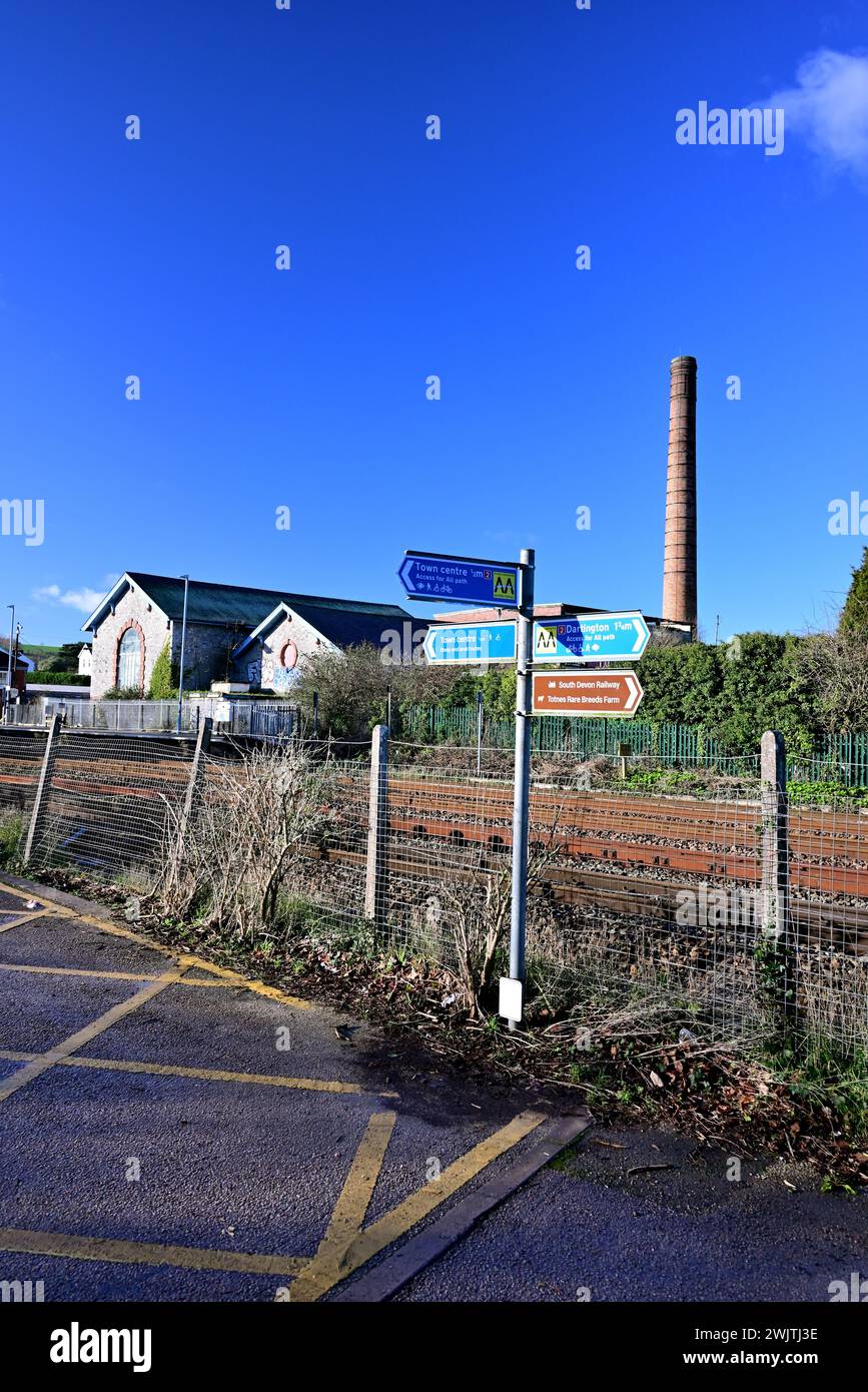 Schild am Bahnhof Totnes und am Kamin der stillgelegten Dairy Crest Fabrik. Stockfoto