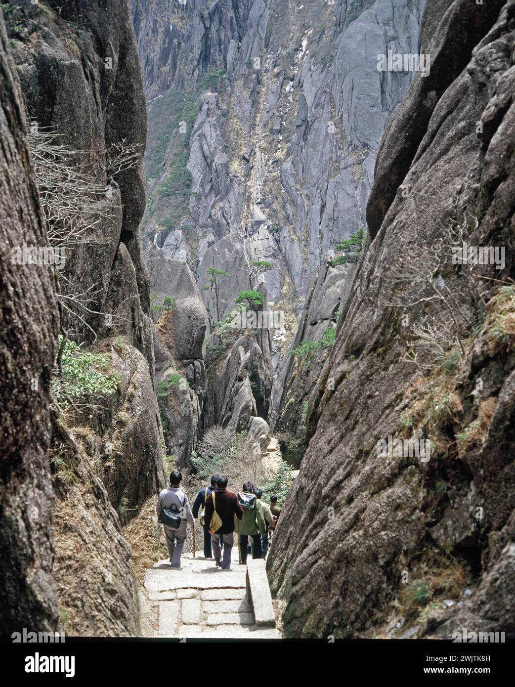 China. Provinz Anhui. Huangshan Mountains. Gruppe chinesischer Männer, die die Stufen des Jade Screen Tower hinabsteigen. Stockfoto