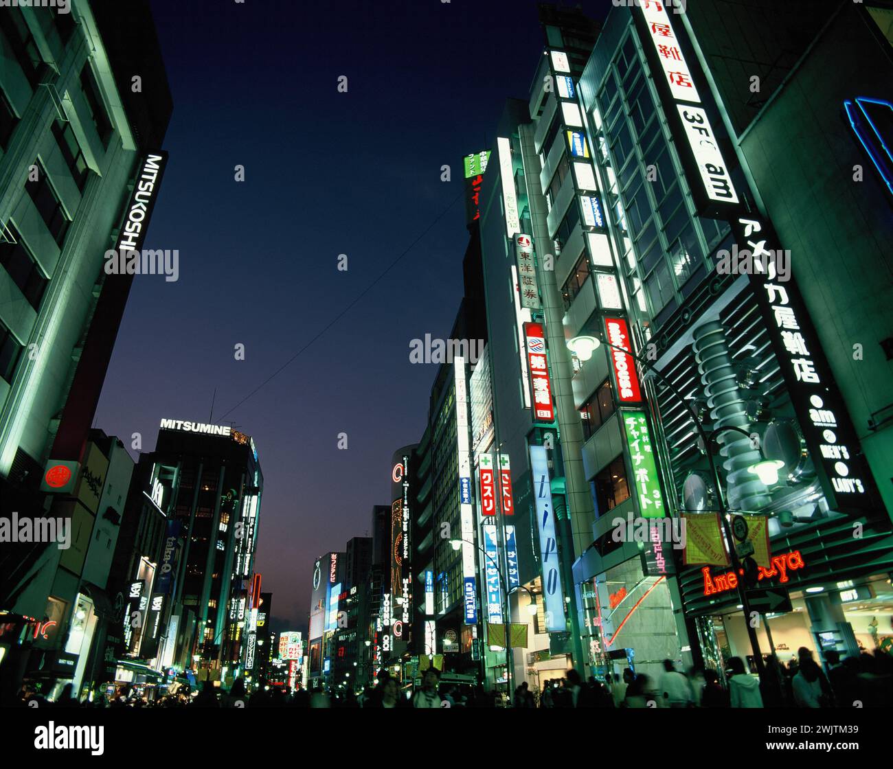 Japan. Tokio. Bezirk Shinjuku. Geschäftige Straßenszene mit hellen Lichtern bei Nacht. Stockfoto