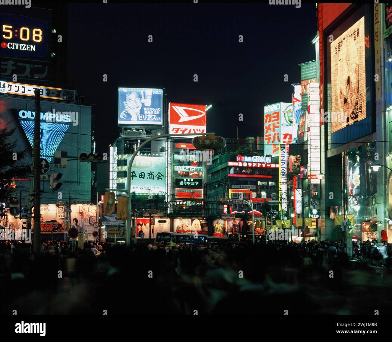 Japan. Tokio. Bezirk Shinjuku. Geschäftige Straßenszene mit hellen Lichtern bei Nacht. Stockfoto