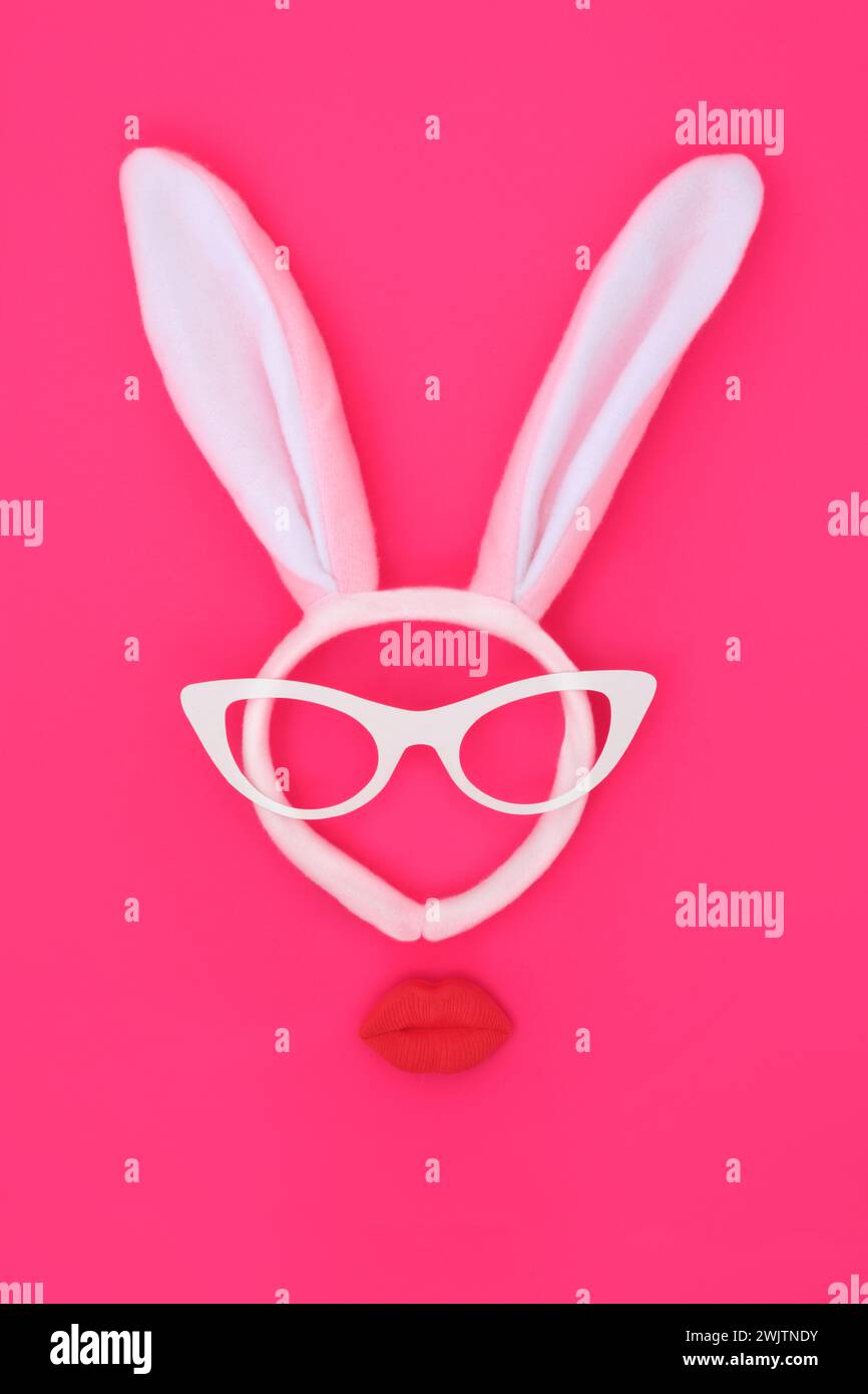 Osterhasen-Ohren-Stirnband mit Pouting Lippen und Brille auf lebhaftem rosa Hintergrund. Abstraktes, bizarres, minimalistisches Gesichtsdesign für die Weihnachtszeit. Stockfoto