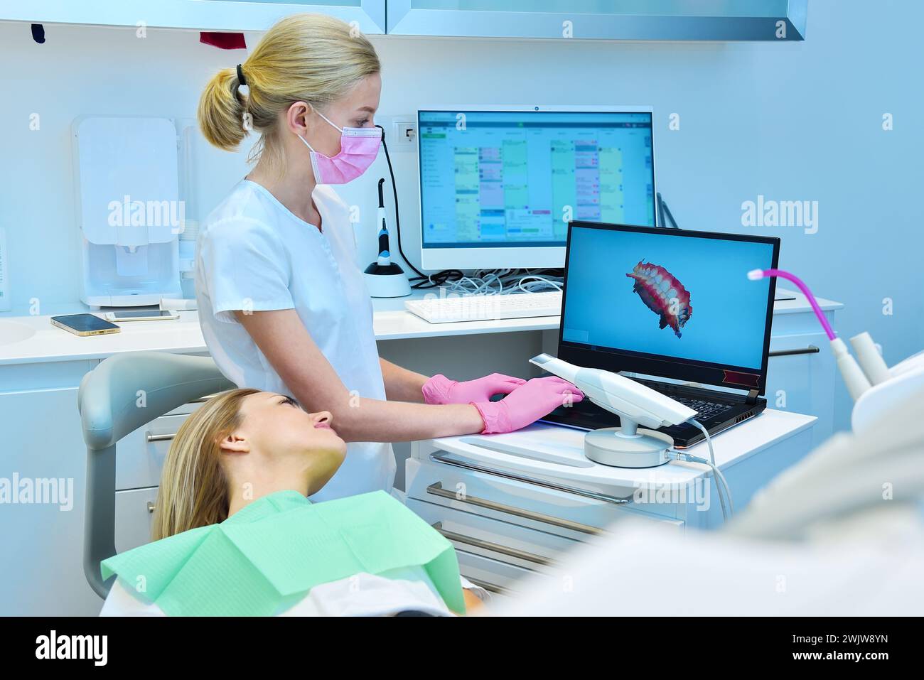 Zahnarztpraxis und Patientin mit Blick auf zahnärztlichen 3D-Scan auf Laptop-Bildschirm. Konzept für Gesundheitswesen und Stomatologie Stockfoto