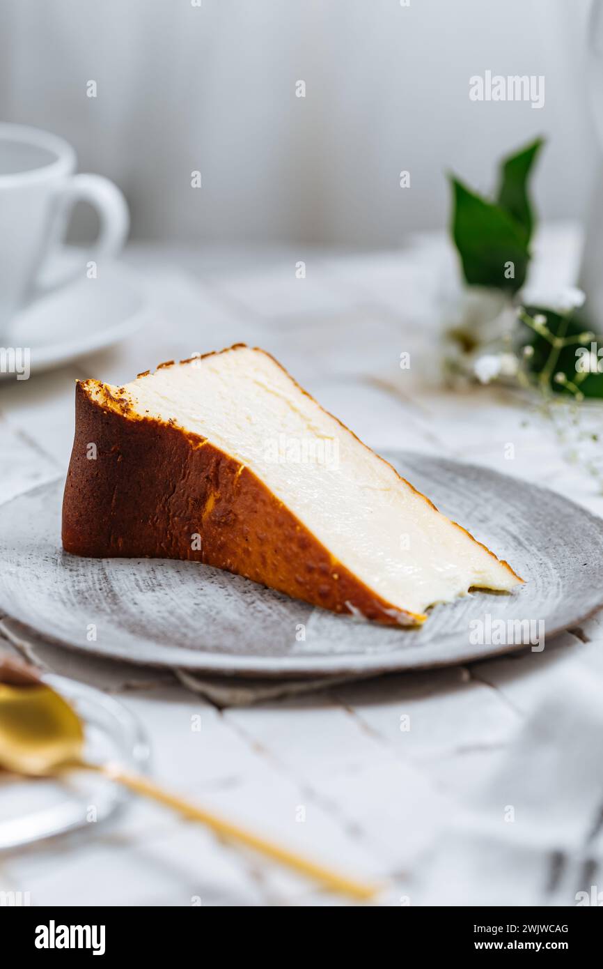 Beliebtes spanisches Dessert namens San Sebastian Käsekuchen. Klassischer baskischer Käsekuchen mit verbranntem Käse. Ein Stück Kuchen auf weißem Hintergrund Stockfoto