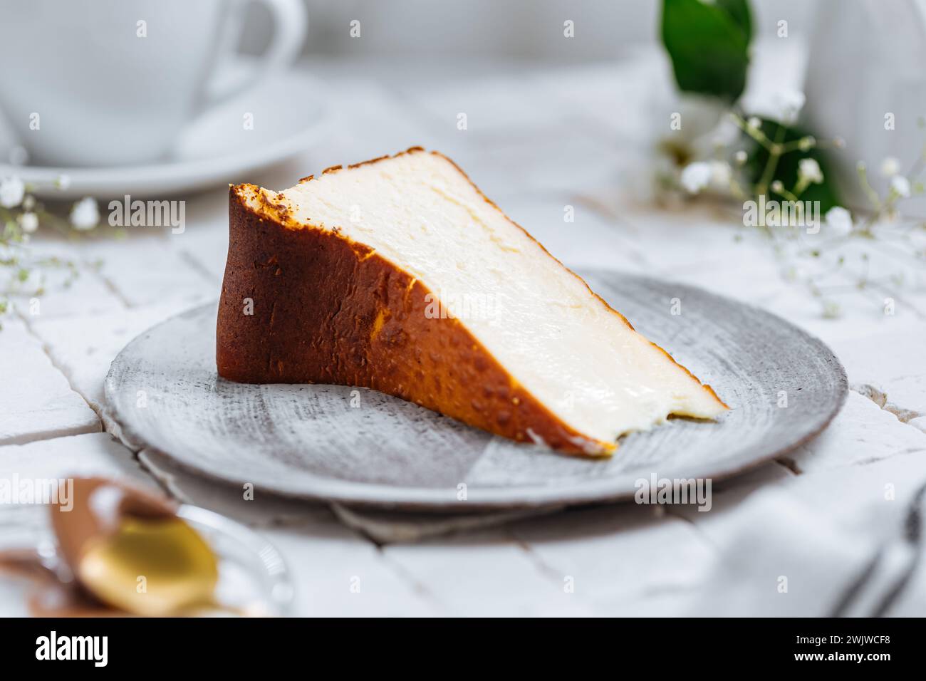 Beliebtes spanisches Dessert namens San Sebastian Käsekuchen. Klassischer baskischer Käsekuchen mit verbranntem Käse. Ein Stück Kuchen auf weißem Hintergrund Stockfoto