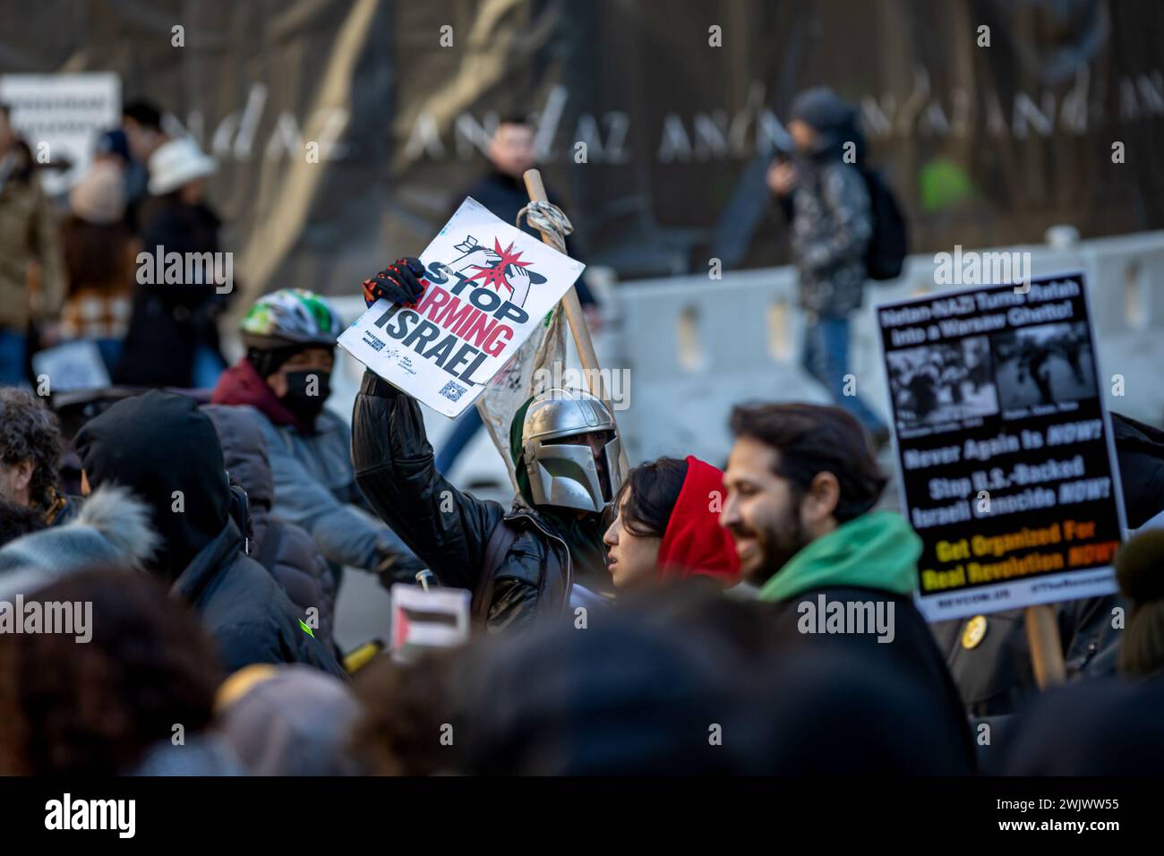 Februar 2024, New York City, New York, Vereinigte Staaten: ein pro-palästinensischer Demonstrant trägt einen mandalorianischen Helm und hält ein Schild mit der Aufschrift „Stop Arming Israel“ während eines stadtweiten Schulbesuchs, der zu einem dauerhaften Waffenstillstand bei einer Kundgebung vor der Hauptfiliale der New York City Public Library am 16. Februar 2024 in New York City aufrief. Das Gesundheitsministerium im Gazastreifen sagte, dass die Zahl der Todesopfer seit Beginn des israelisch-Hamas-Konflikts am 7. Oktober 2023 über 30.000 Menschen liegt, davon etwa zwei Drittel Frauen und Kinder. (Foto: © Michael Nigro/Pacific Press via ZUMA Press Stockfoto