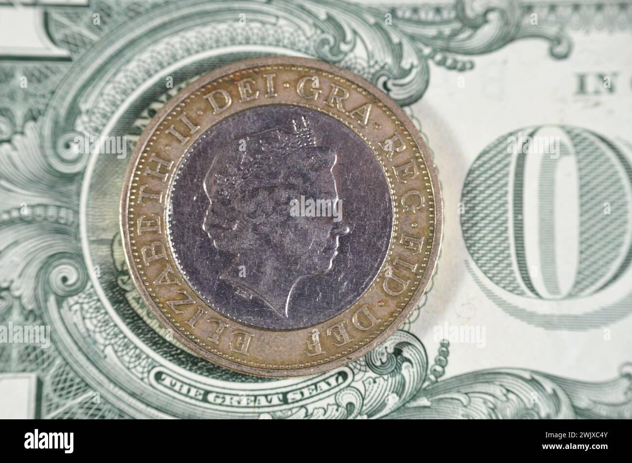 US-Dollar und zwei britische Pfund-Münze mit Königin Elizabeth II. Auf der Vorderseite und vier konzentrischen Kreisen für die Eisenzeit, Industrial Revo Stockfoto