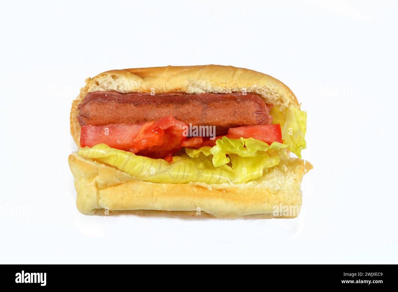 Hot Dog in einem Brötchen mit Salat und Tomatenscheiben, gegrillte Rinderwurst namens wiener (Wiener Wurst) und frankfurter Freispruch mit Salat und Tomate, in Stockfoto