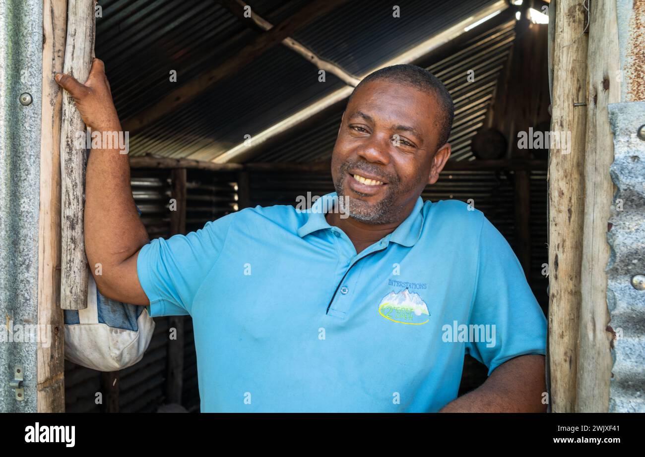 Ein männlicher Mathematiklehrer steht in der Tür der Küchenhütte der Jambiani Secondary School in Sansibar, Tansania. Stockfoto