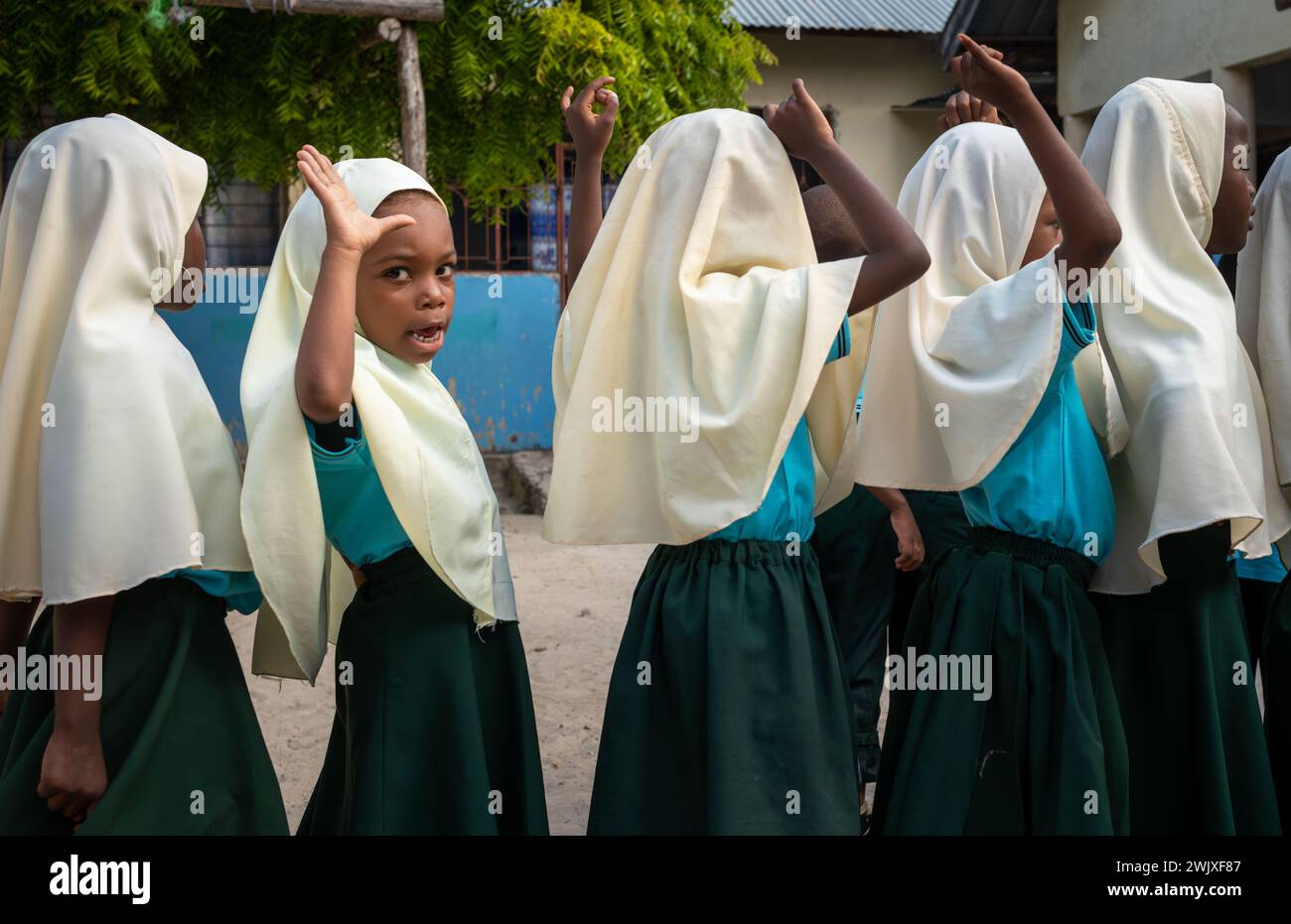 Junge muslimische Mädchen bei der morgendlichen Versammlung in der Jambiani Primary School in Jambiani, Sansibar, Tansania. Stockfoto