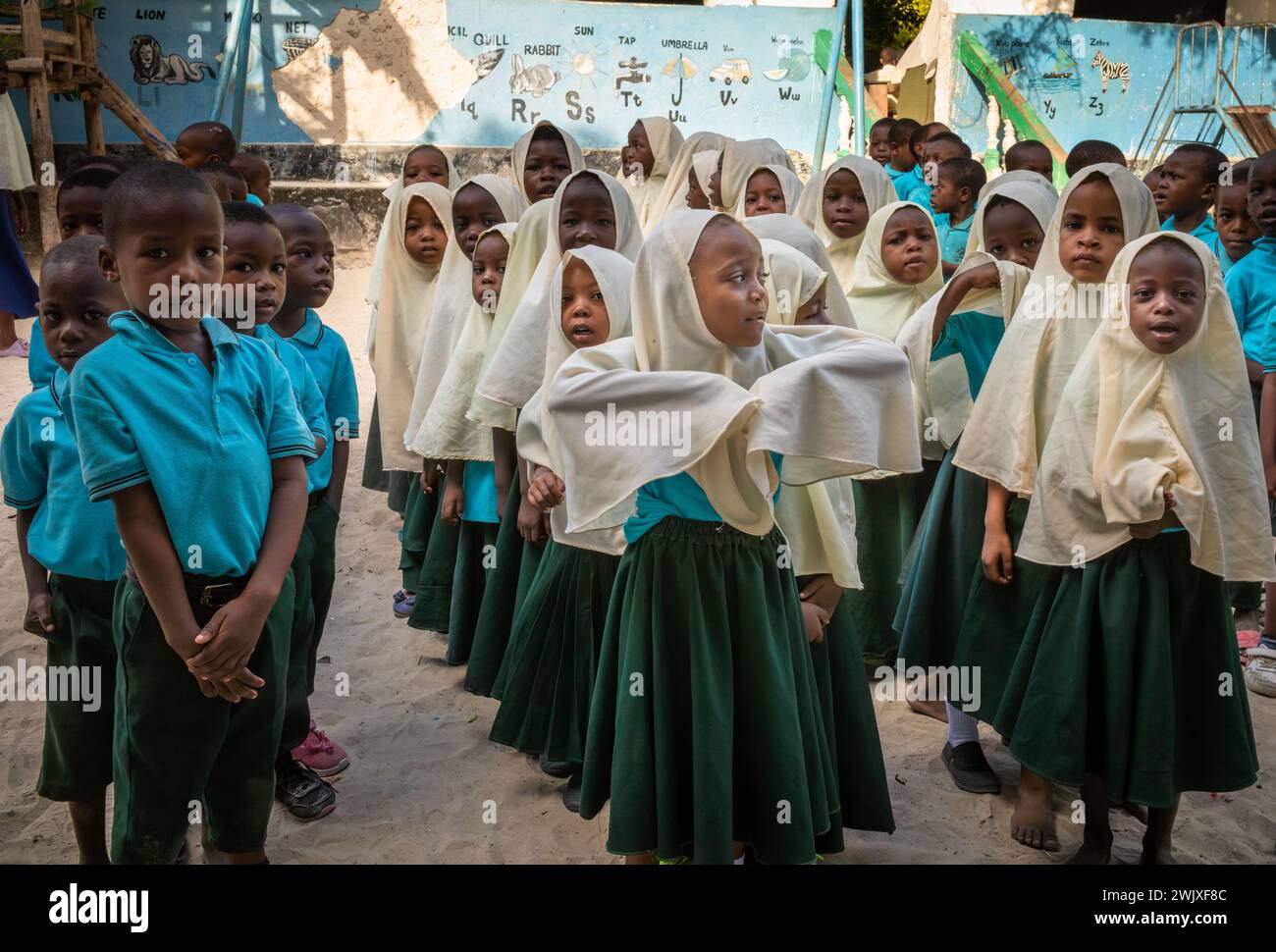 Junge muslimische Jungen und Mädchen an der Jambiani Primary School bei der Morgenversammlung in Jambiani, Sansibar, Tansania. Stockfoto