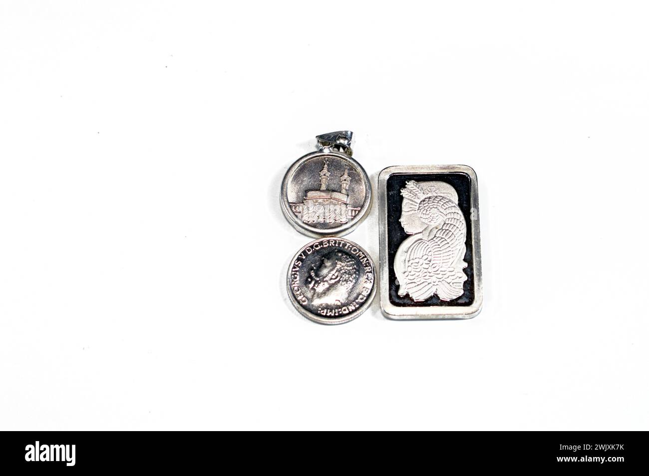 Silber Edelmetall-Unze-Barren aus reinem Silber, islamisches Pfund zeigt Kaaba, Masjid Haram und den Souverän, eine britische Silbermünze, eine Bullion c Stockfoto