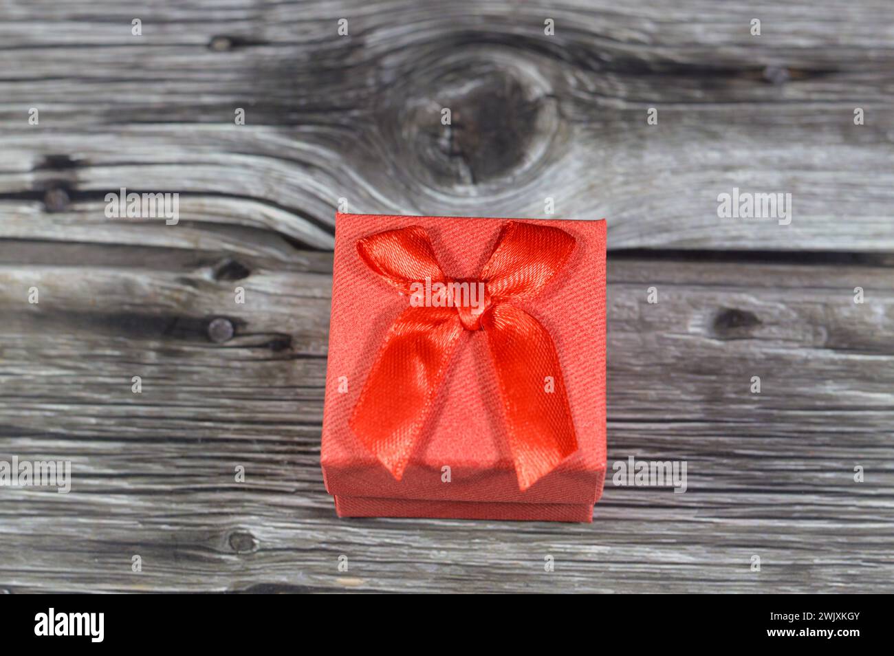Eine kleine rote Geschenkbox für Edelmetalle wie Goldringe, Ohrringe, Diamantringe, kleines Geschenkpaket für Heiratsanträge und wertvolle Geschenke für j Stockfoto