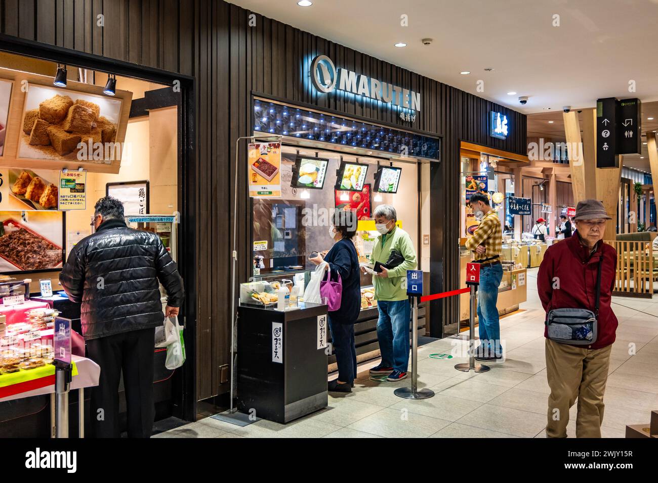 Leute, die in lokalen Imbissgeschäften einkaufen. Moriya, Japan. Stockfoto