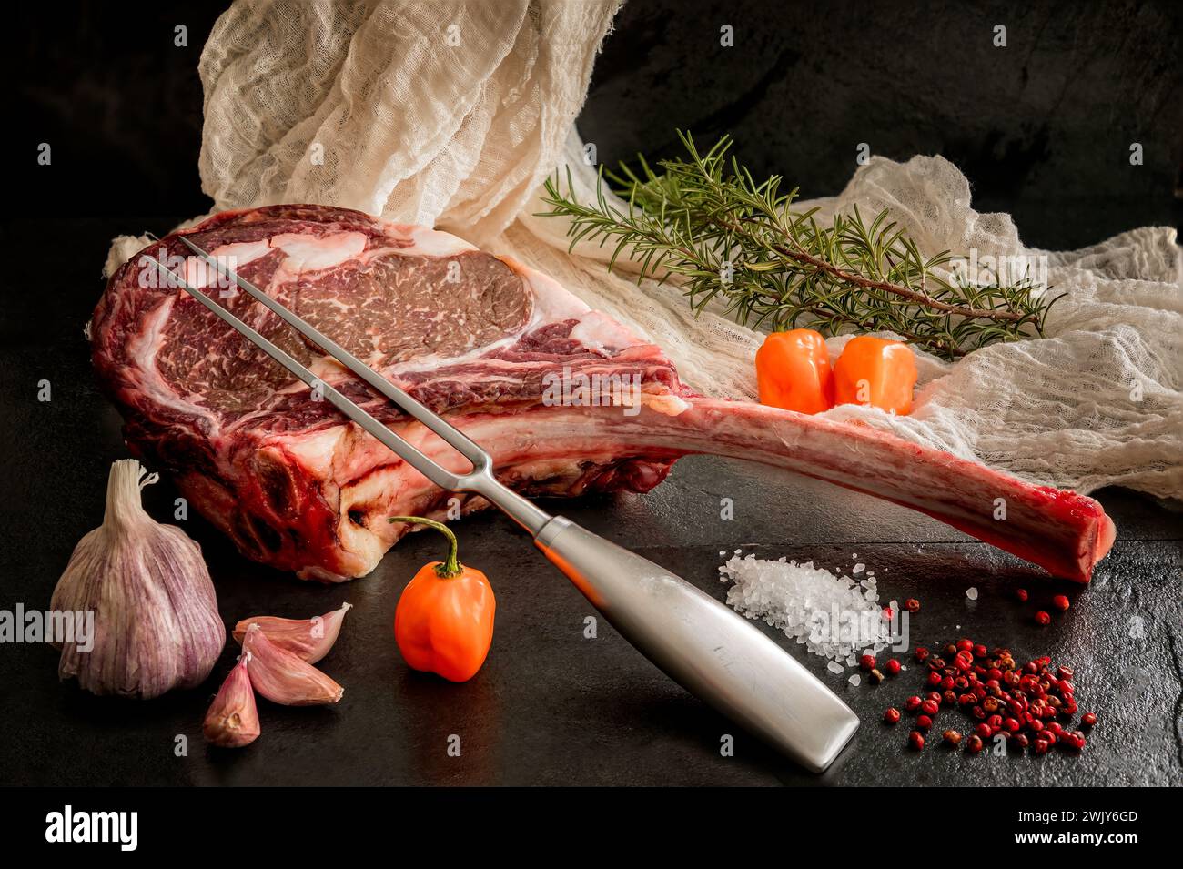Wagyu Tomahawk Steak auf Schieferboden mit Salz, Pfeffer, Knoblauch und Paprika Stockfoto