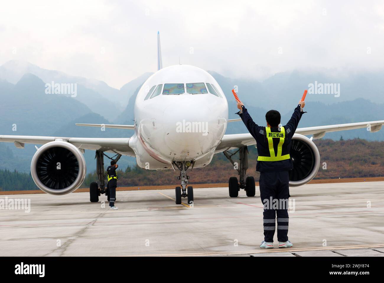 Chongqing, China. Februar 2024. Ein Besatzungsmitglied schickt ein Passagierflugzeug an, um am 16. Februar 2024 in Chongqing, China, in den Flughafen zu gelangen. (Foto: Costfoto/NurPhoto) Credit: NurPhoto SRL/Alamy Live News Stockfoto