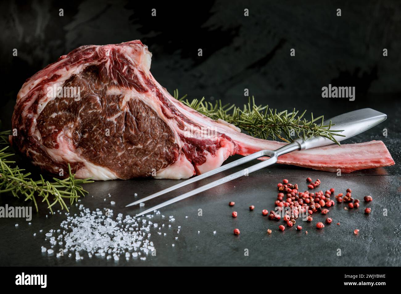 Wagyu Tomahawk Steak auf Schieferboden mit Salz, Pfeffer, Knoblauch und Paprika Stockfoto