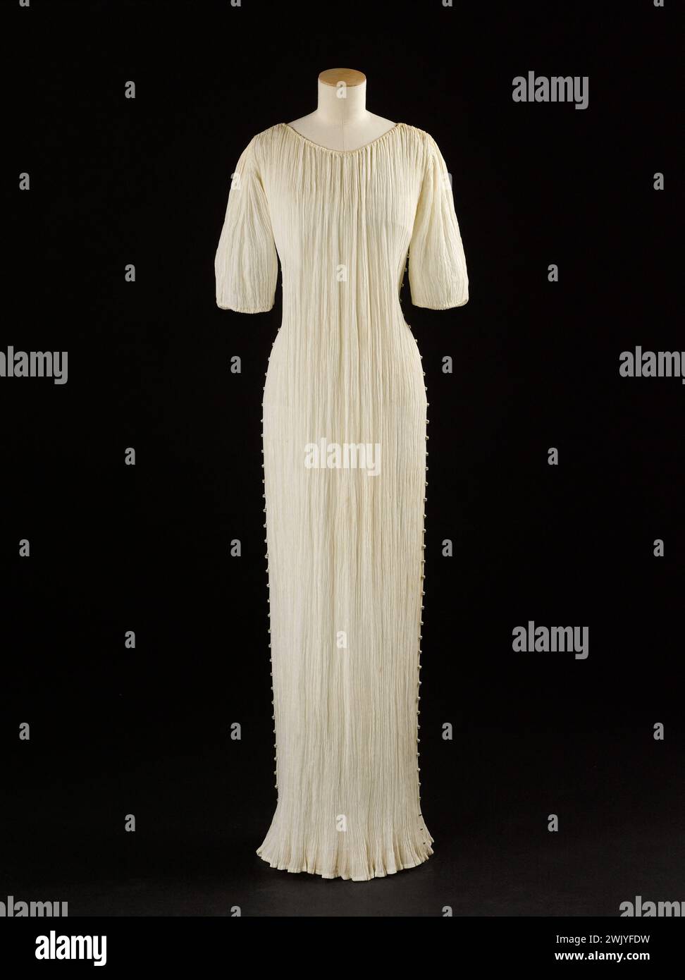 Mariano Fortuny (1871-1949). Delphos-Kleid. Weiße Leinwand, weiße, gelbe und blaue muranoglasperlen. Jahr 1940. Galliera, Modemuseum der Stadt Paris. 101885-3 Annies 1940 40, Haute Couture, Ärmel, weiblicher Modus, weibliches Modell, Perlen, delphos-Kleid, langes Kleid, weiße Leinwand, muranoglas Stockfoto