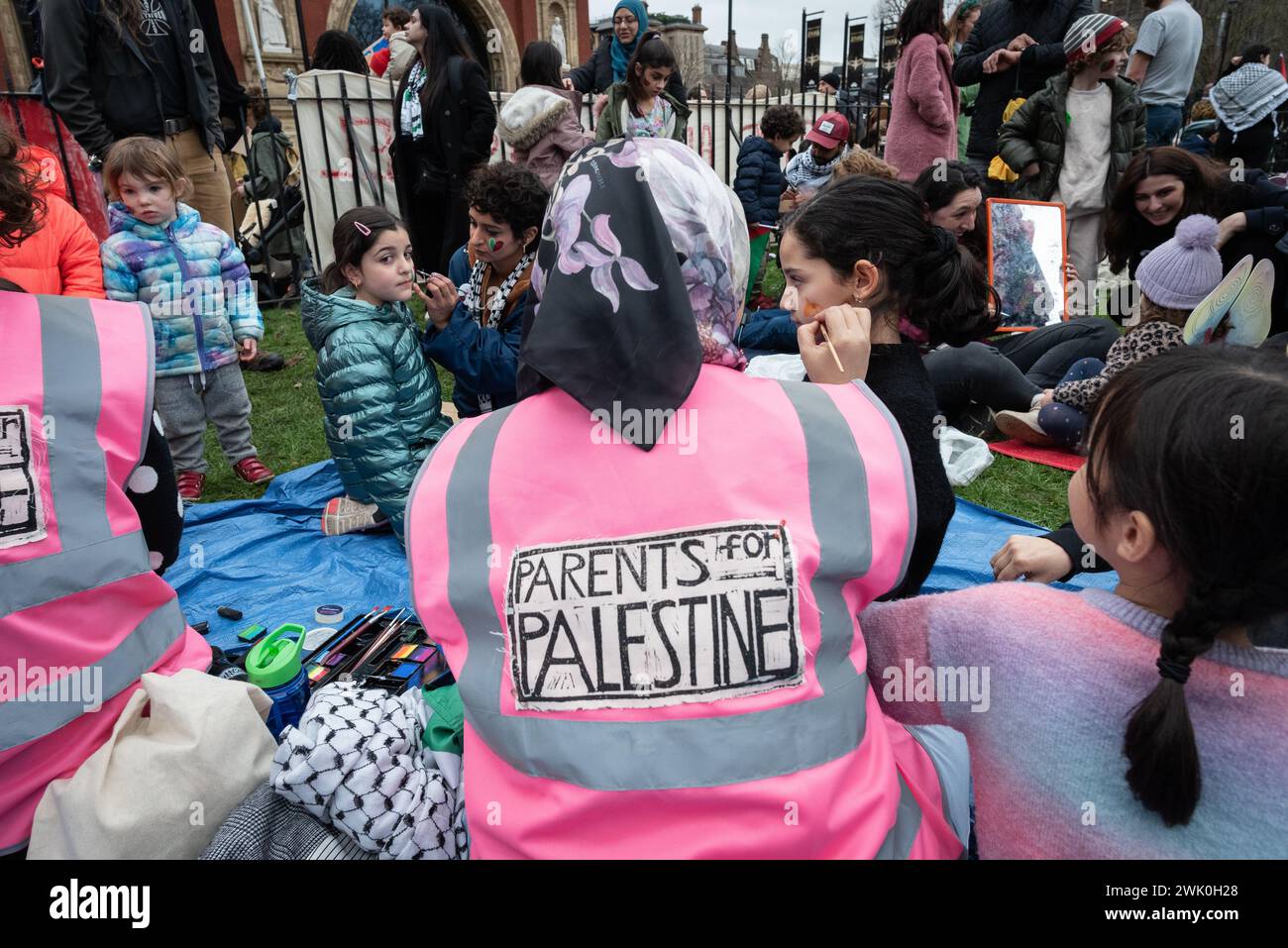 London, Großbritannien. 17. Februar 2024. Eltern für Palästina unterhalten Kinder mit Gesichtsbemalung, bevor sie sich Zehntausenden palästinensischer Unterstützer anschließen, die im Rahmen eines "Globalen Aktionstages" für Gaza zu einer Kundgebung in der Nähe der israelischen Botschaft marschieren und einen sofortigen Stopp des israelischen Krieges gegen die belagerte Enklave fordern. Quelle: Ron Fassbender/Alamy Live News Stockfoto