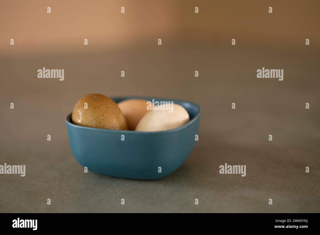 Die drei hoffrischen Bio-Eier in einer Schüssel auf einem grünen Betontisch Stockfoto