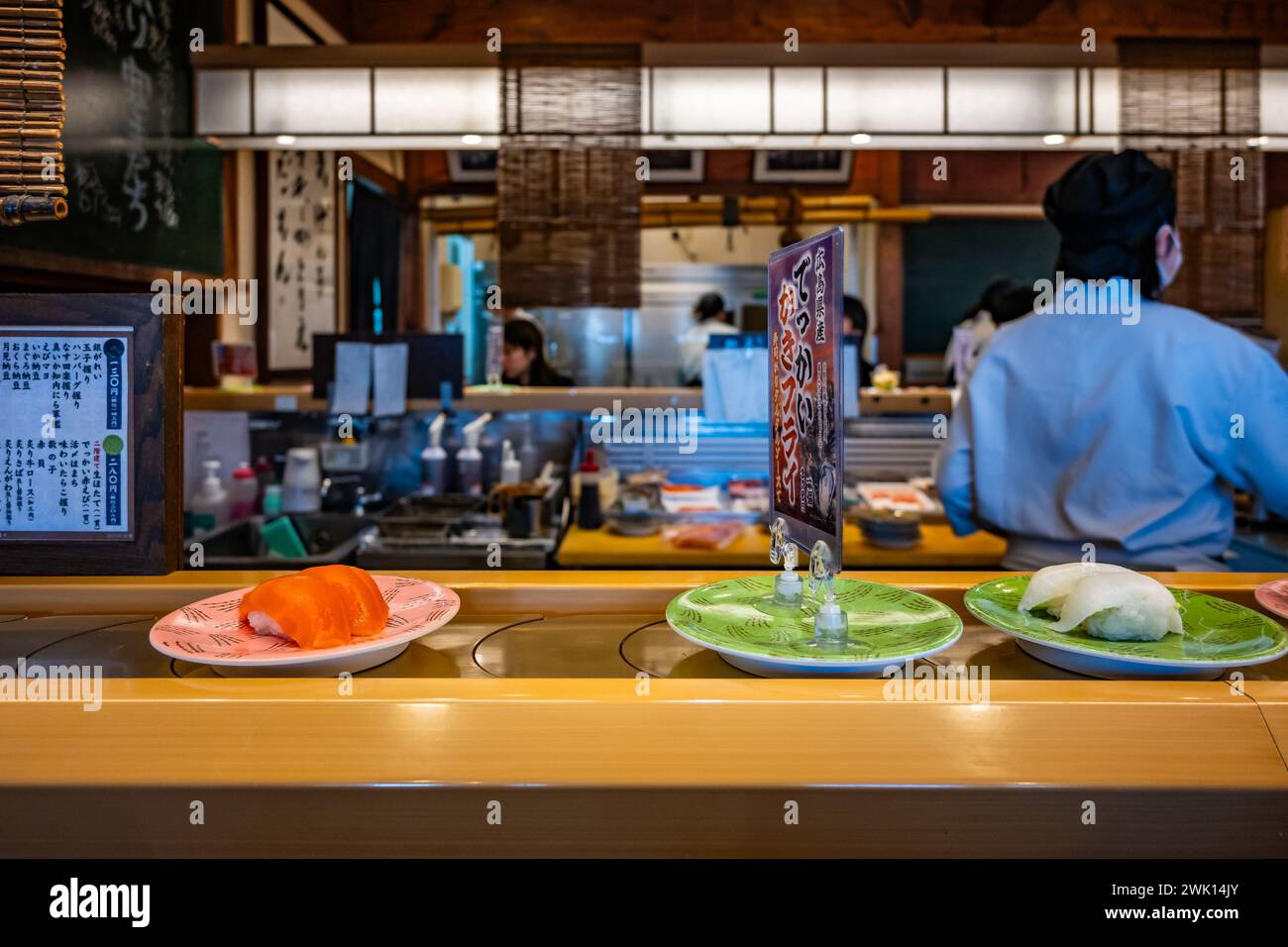 Kleine Teller mit Speisen, die auf einem Karussell in einem lokalen Kaiten-Sushi-Restaurant serviert werden. Hokkaido, Japan. Stockfoto