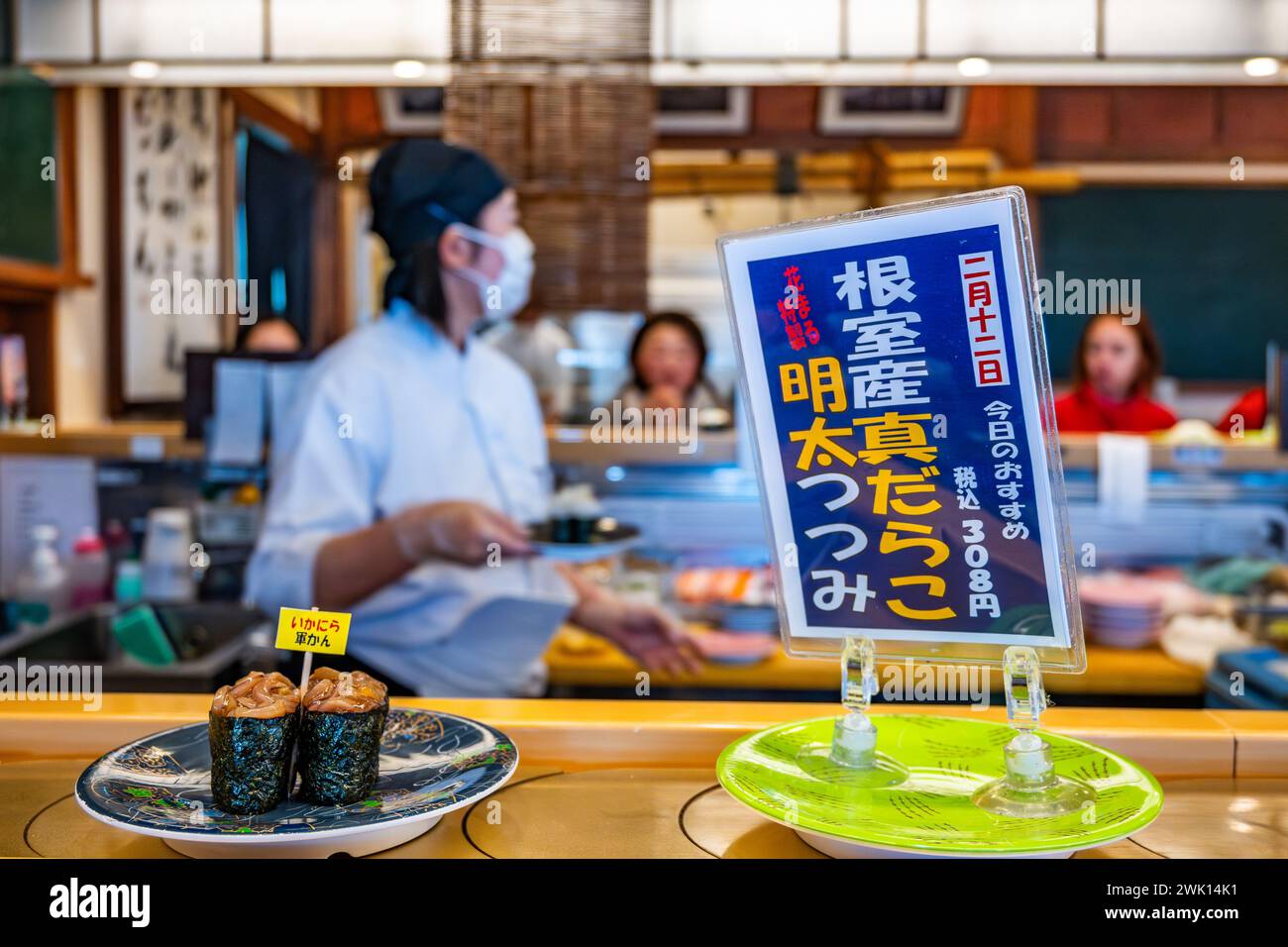 Kleine Teller mit Speisen, die auf einem Karussell in einem lokalen Kaiten-Sushi-Restaurant serviert werden. Hokkaido, Japan. Stockfoto