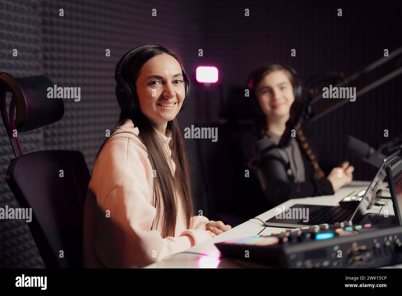 Selbstbewusstes weibliches Duo in einem professionellen Podcasting-Studio Stockfoto