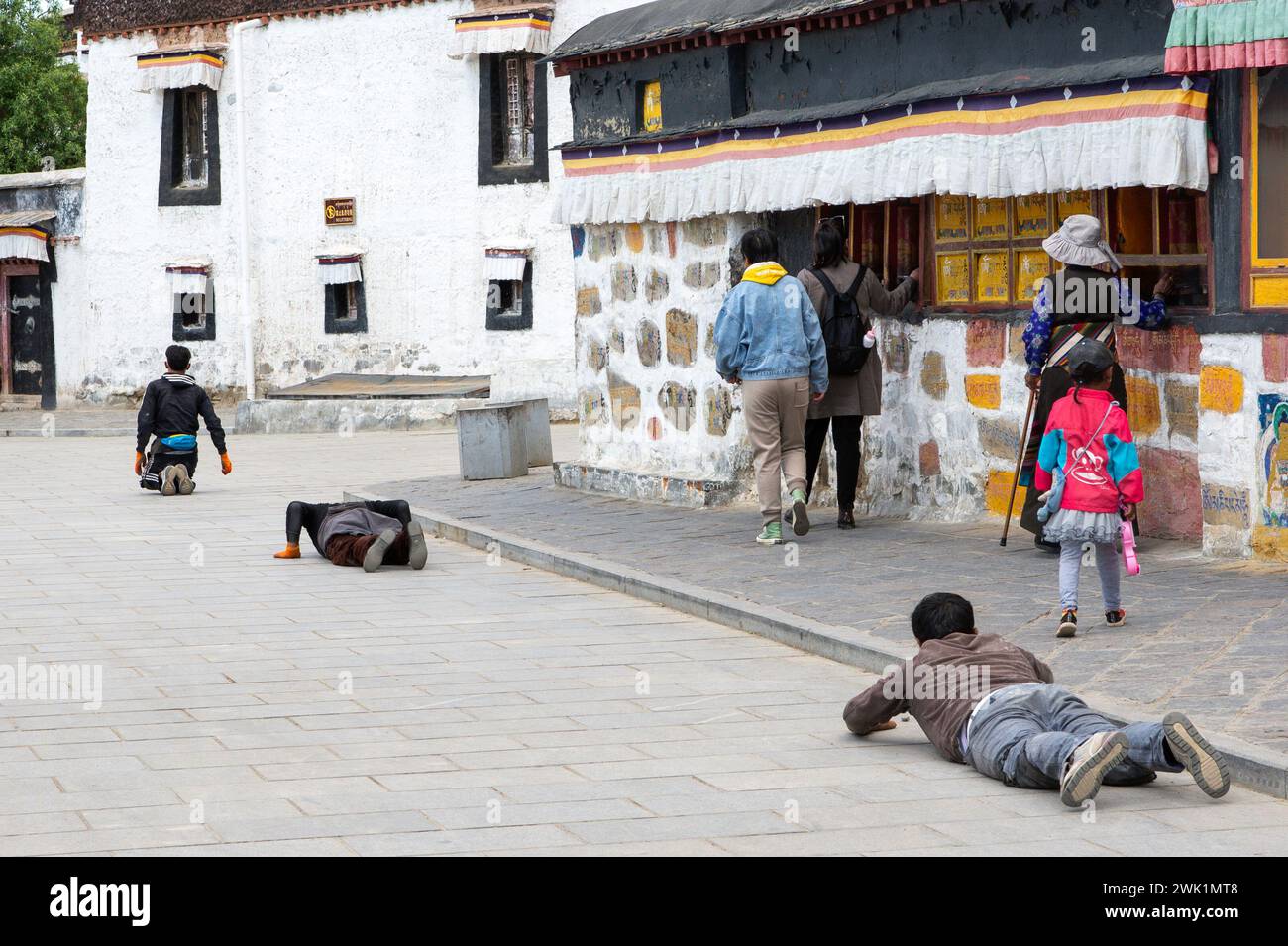 Pilger umrunden das Kloster auf dem Lingchor (heiliger Pfad) außerhalb der Mauern des Taschi Lhunpo Klosters in Shigatse, Autonomes Gebiet Tibet. Stockfoto