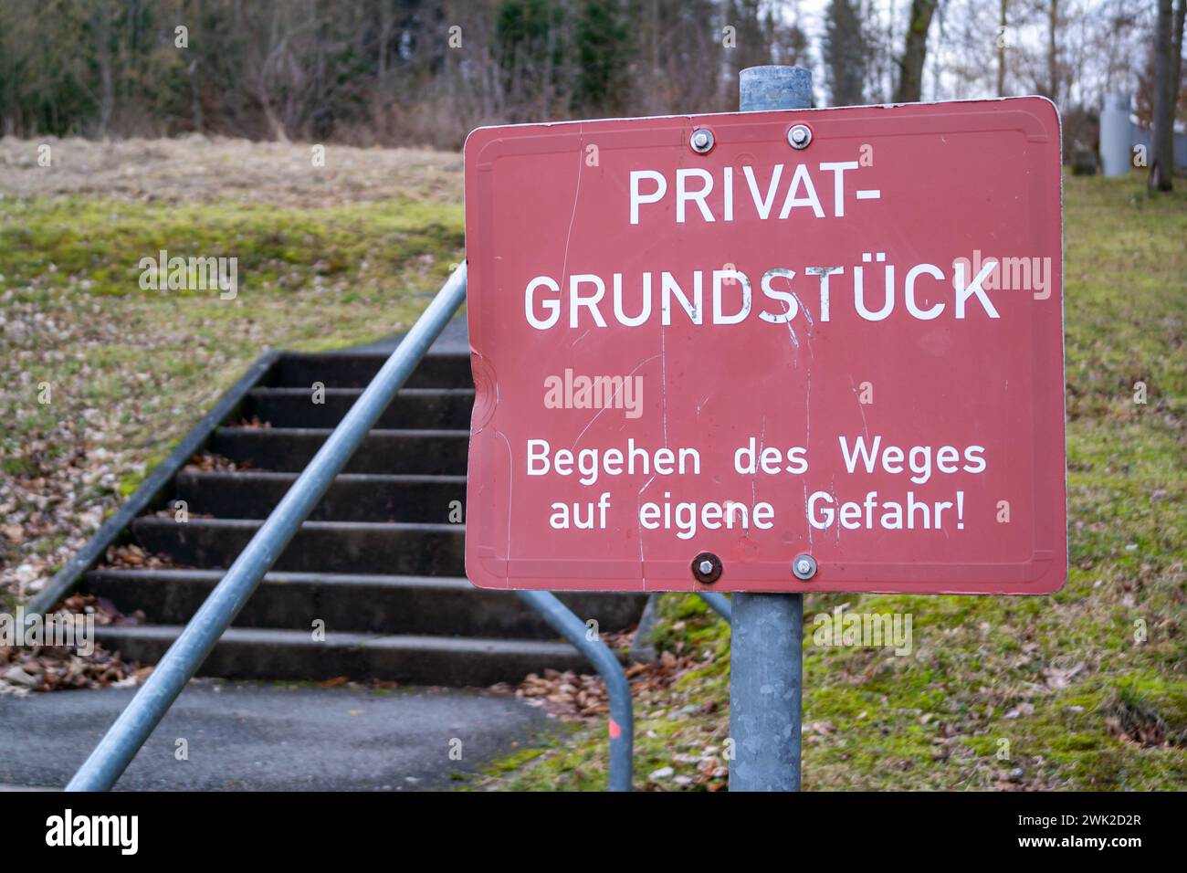 Warnung/Hinweisschild rot-weiß mit der Aufschrift: "Privatgrundstück - Begehen des Weges auf eigene Gefahr!" Stockfoto