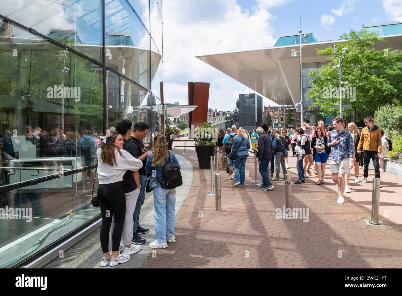 Personen, die vor dem Van Gogh Museum stehen, mit der Badewanne des Stadtmuseums - stedelijk Museum, im Hintergrund. Stockfoto