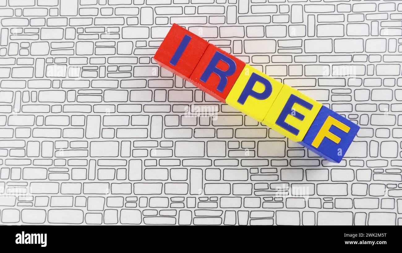 Schreiben von IRPEF-Einkommensteuerbriefen auf Holzwürfeln Backsteinhintergrund. Stockfoto Schreiben von IRPEF-Einkommensteuerbriefen auf Holzwürfeln Backsteinhintergrund. Stockfoto