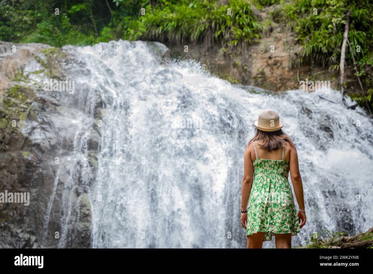 Eine Reisende Frau denkt über einen Wasserfall im peruanischen Dschungel nach. Stockfoto