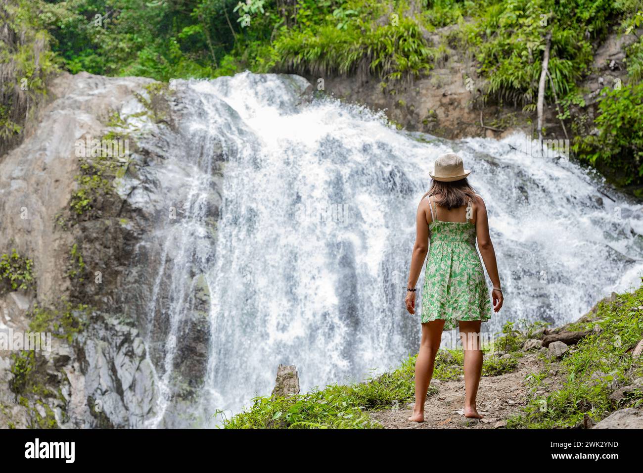 Eine Reisende Frau denkt über einen Wasserfall im peruanischen Dschungel nach. Stockfoto