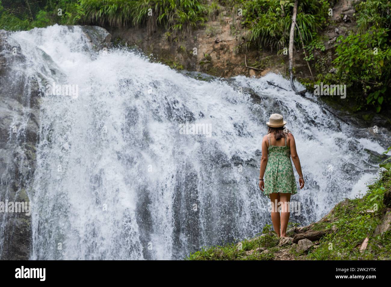 Eine Reisende Frau denkt über einen Wasserfall im peruanischen Dschungel nach. Stockfoto