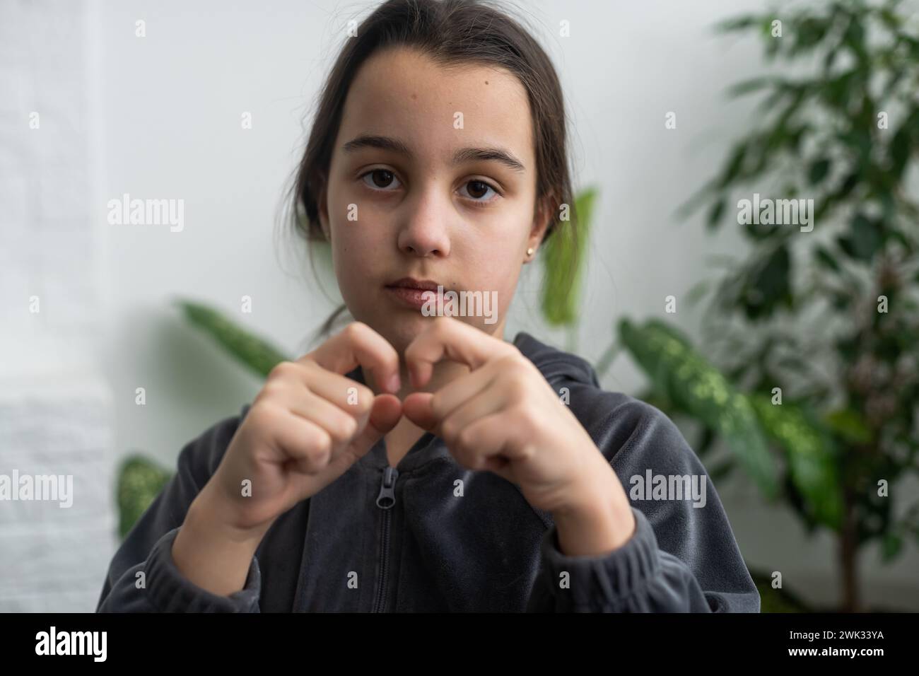 Wunderschönes, lächelndes, taubes Mädchen, das Gebärdensprache benutzt. Stockfoto