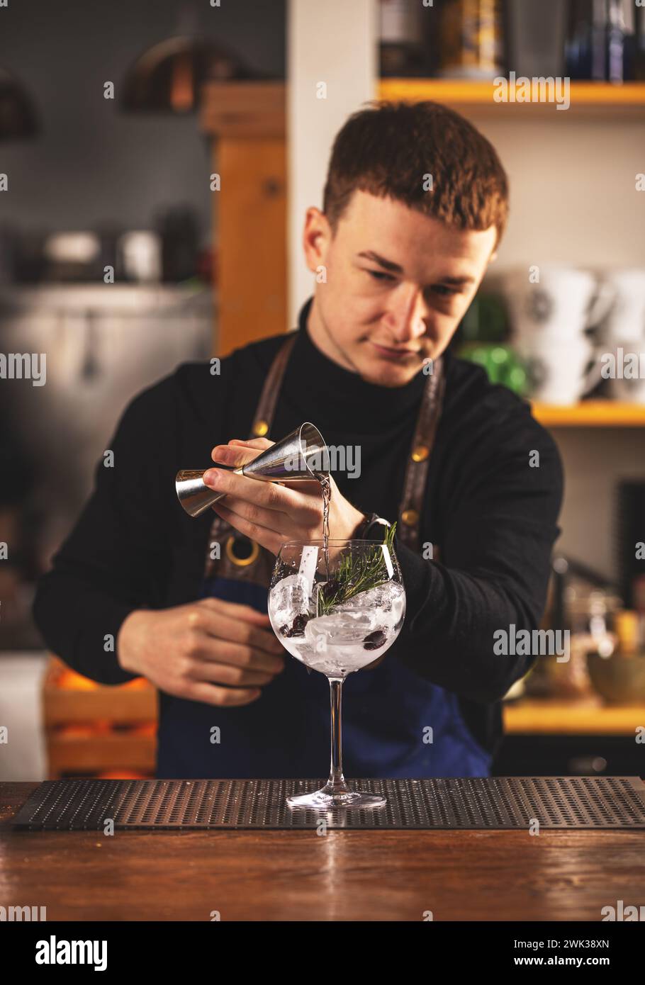 Barkeeper macht einen alkoholischen Drink und misst Alkohol mit Jigger Stockfoto