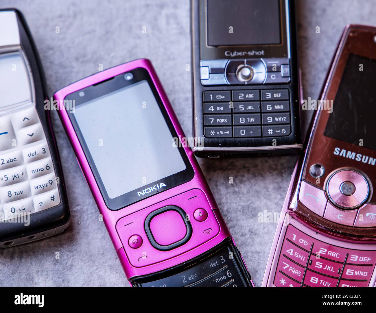 Sortiment an Vintage-Mobiltelefonen aus den frühen 2000er Jahren auf strukturierter Oberfläche Stockfoto