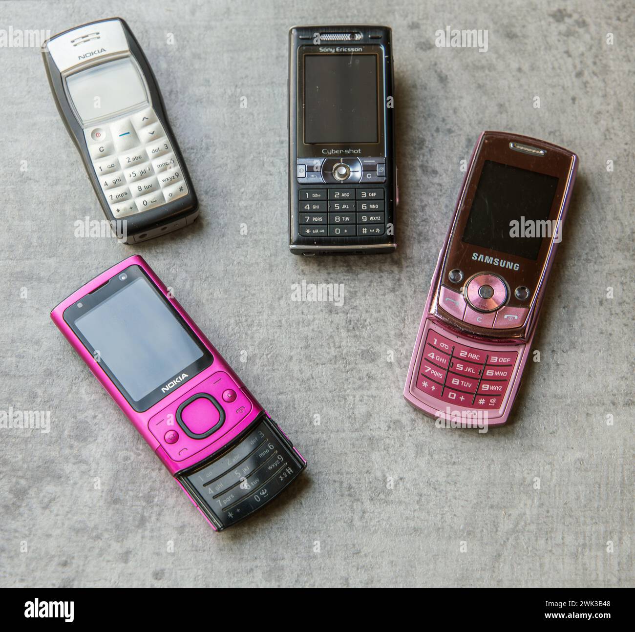 Vintage-Sammlung alter Handys verschiedener Marken auf einem konkreten Hintergrund Stockfoto