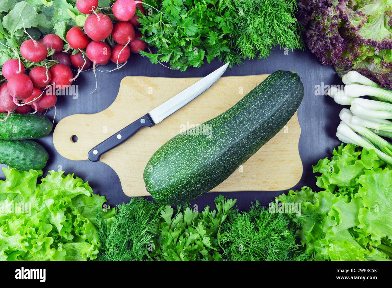 Blick von oben auf gesundes Essen, Kräuter und Gewürze auf rustikalem hölzernem Hintergrund. Bunte Gemüse-Zutaten für leckeres veganes und diätetisches Kochen. Vegetarische Küche Stockfoto