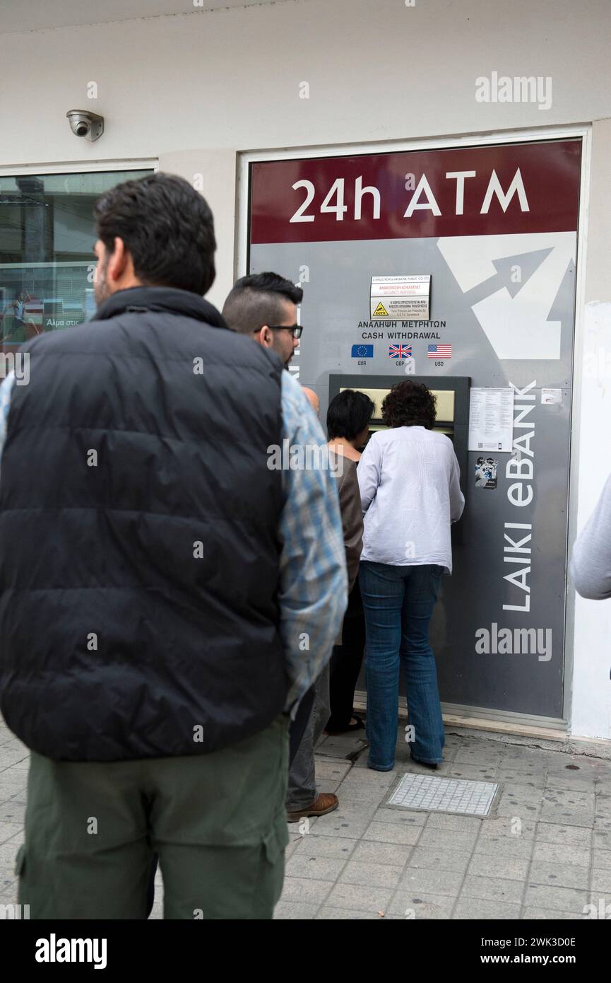 Leute in Nikosia ziehen Geld an einem Geldautomaten der Popular Bank. Stockfoto