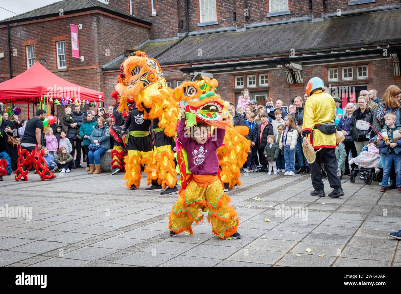 Sonntag, 18. Februar; Warrington, Cheshire, England. Warrington Town feierte das chinesische Neujahrsfest 2024. Hongjun Laozu, ein alter taoistischer Mönch, ist derjenige, der den Nian gefangen nahm. 2024 ist das Jahr des Drachen. Die Aufführung beinhaltete einen kleinen Jungen, der als Drache verkleidet war. Quelle: John Hopkins/Alamy Live News Stockfoto